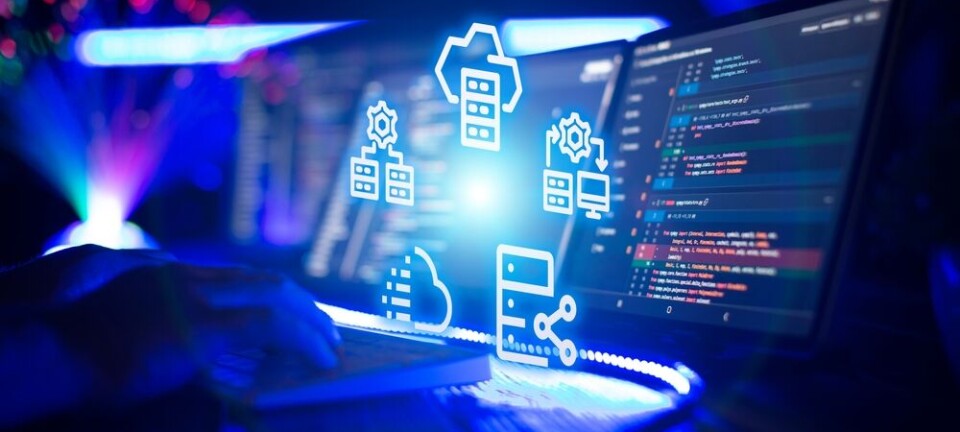 Developer typing near monitors showing code and glowing cloud data storage icons.