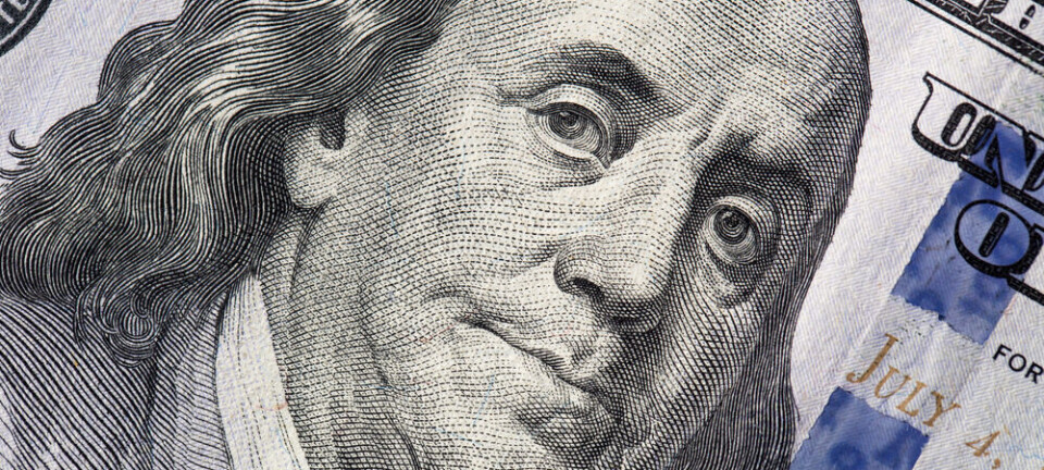Macro view of a one hundred dollar bill showing detailed texture and design.